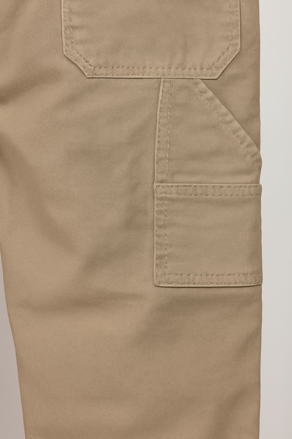 Close-up of rear utility pocket stitching on handmade khaki pants